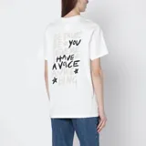 Remera de algodón jersey color blanco, con cuello redondo acanalado y mangas cortas. Presenta un logo estampado en contraste en el frente y una estampa distintiva en la espalda.