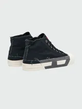 Zapatillas de caña alta Diesel modelo S-D-Verse, confeccionadas en lona negra con bordes deshilachados. Presentan puntera de goma blanca, suela con diseño geométrico en contraste y etiqueta roja con logo en la lengüeta.