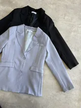 Blazer verde esmeralda de corte clásico con solapas y cierre con botones.