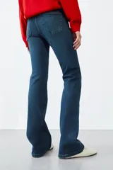Jeans bootcut de tiro medio color azul oscuro, con cinco bolsillos y pespuntes a contraste. Cierre frontal con cremallera y botón.