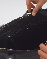 Cartera tipo tote de cuero natural con cierre superior, doble asa de hombro y bolsillo interior.