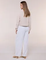 Camperita de tela liviana color beige, de silueta entallada con cuello a la base y abotonadura frontal con botones a tono. Cuenta con dos bolsillos con solapa en el frente, mangas largas con puños abotonados y largo a la cintura.