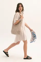 Vestido corto color arena de lino, con cuello en V y mangas cortas.