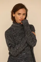 Polerón de tejido de punto con efecto nevado, cuello alto y mangas largas. Presenta un diseño holgado y un parche decorativo en la manga derecha.