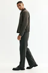 Pantalón de vestir de corte relajado, con piernas rectas, pinzas frontales y pliegues marcados. Presenta cierre oculto con botón y corchete, bolsillos laterales al bies y bolsillos traseros insertados.