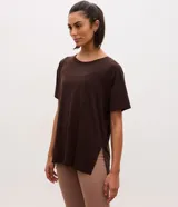 Remera Get Over de microfibra en color marrón, de corte amplio y regular, con cuello redondo, mangas cortas, aberturas laterales en el ruedo y diseño más largo en la parte trasera.