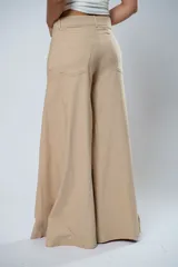 Pantalón de vestir color beige, de corte palazzo y tiro alto.