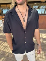 Camisa de manga corta con textura tipo waffle, color negro, con cuello clásico y cierre frontal de botones claros.