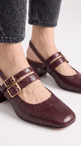 Zapato de tacón bajo destalonado de cuero bordó con textura croco, punta cuadrada, doble tira en el empeine con hebillas metálicas doradas y taco bloque.