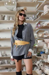 Camisa oversize a rayas grises, con cuello y puños anchos en contraste de color blanco, cierre frontal con botones y bolsillo ojal en el pecho.