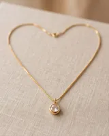 Collar de bronce con cadena fina y dije redondo con circonia blanca engastada.