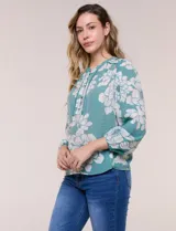 Blusa de gasa texturizada color verde con estampado floral blanco, cuello mao con escote en V y botones frontales. Cuenta con mangas 3/4 abullonadas y detalles de puntilla calada en el pecho.