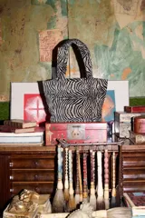 Cartera tipo mini tote con estampado animal print de cebra, confeccionada en algodón con relleno acolchado y doble asa de mano.