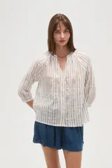 Camisa de algodón con diseño de rayas verticales y detalles bordados. Presenta cuello en V, cierre frontal con botones y mangas tres cuartos con terminación elástica.