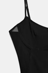 Top negro de tirantes finos con aros, escote en pico y detalles de paneles de malla semi transparente en los laterales y el frente.