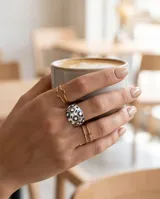 Anillo de acero de diseño bombé esmaltado en tonos blancos, negros y grises, con incrustaciones de nácar.
