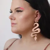 Par de aros colgantes con forma de serpiente, color rojo metalizado.