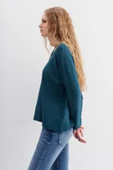 Remera de algodón peruano con textura jaspeada, de corte holgado y diseño de mangas largas con ajuste en la muñeca.