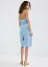 Top de denim suave color celeste con cuello halter, escote en V profundo y cordón ajustable en la cintura.