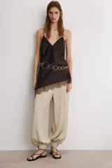 Top lencero de tejido satinado color marrón oscuro, con escote en V y tirantes finos ajustables. El bajo es asimétrico y está adornado con encaje a tono.