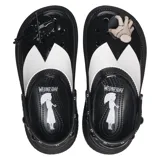 Zuecos Crocs Stomp de plataforma alta, color negro con detalles en blanco, con correa trasera ajustable y dijes Jibbitz inspirados en la serie Wednesday.
