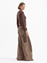 Pantalon de jean de corte wide leg en color marrón, con diseño de parches en tonos contrastantes y estilo carpintero. Presenta bolsillos diagonales frontales y bolsillos plaque en la parte posterior.
