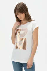 Remera de algodón blanca, de corte holgado, manga corta con vuelta y cuello redondo. Cuenta con un estampado frontal abstracto con trazos en tonos marrón y foil dorado.