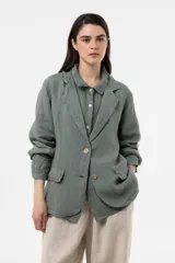 Chaqueta de lino verde militar de calce relajado, con solapa clásica, cierre frontal con dos botones grandes y bolsillos delanteros con solapa.