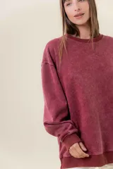 Sweater de tejido suave con lavado efecto vintage, color rosa fucsia, de calce oversize y cuello redondo.