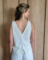 Musculosa color crudo con escote en V y textura acanalada vertical.