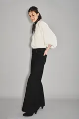 Jean de corte oxford en color negro, con tiro alto y diseño de pierna ancha. Confeccionado en denim de algodón, presenta cierre frontal con botón y bolsillos laterales y traseros.