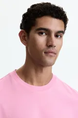 Remera de algodón liviano color rosado, con cuello redondo y diseño clásico de manga corta.