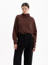 Polera de tejido de punto color marrón, con cuello alto y diseño holgado de corte oversize.