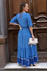Vestido largo azul con estampado floral, escote en V, botones en el frente y volado en el ruedo.