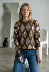 Sweater de punto color chocolate con diseño de rombos formados por lentejuelas doradas y plateadas. Presenta cuello redondo, mangas largas y puños acanalados.