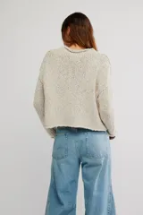 Sweater de punto grueso color beige, de calce amplio y largo corto, con escote redondo, mangas caídas y terminaciones acanaladas en tejido abierto.