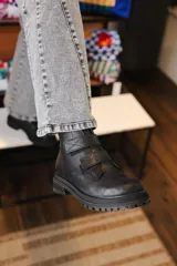 Bota corta de cuero negro con suela track y cierre mediante tiras con velcro en el empeine.