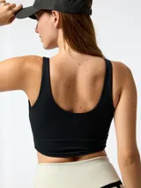 Calzas deportivas de tiro alto en color beige con franjas laterales negras y diseño en V en la cintura.
