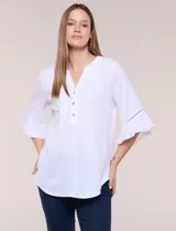 Blusa blanca de crepe crinkle con escote en V, media abotonadura frontal con botones nacarados, alforzas verticales en la pechera y mangas tres cuartos acampanadas con detalle de encaje horizontal.