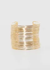 Pulsera brazalete rígido color dorado, con diseño de múltiples hilos finos.