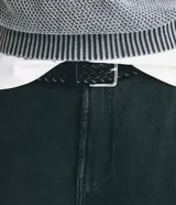 Cinturón trenzado de poliuretano color negro, de ancho mediano, con hebilla cuadrada de metal plateado.