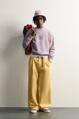 Buzo relaxed fit Fruit of the Loom x Zara color lila con efecto lavado, cuello redondo y manga larga. Estampación frontal de texto multicolor y acabado en rib.