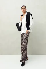 Camisa negra de manga larga con cuello clásico y botones frontales. El tejido presenta una textura arrugada o plisada, y los puños tienen un frunce elástico.