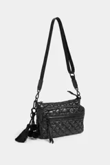 Cartera tipo bandolera de diseño matelasse en color negro, con cierre superior, bolsillo frontal con cierre, tira de hombro con cadena plástica y detalles colgantes de pompones y borlas.