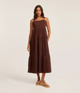 Vestido midi de Blue Steel confeccionado en sarga de algodón, con diseño de corte amplio, escote recto y breteles finos. Presenta una falda con cortes horizontales que aportan volumen y movimiento.