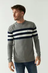 Sweater gris con rayas horizontales azul marino y blancas, de manga larga y cuello redondo.