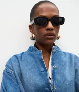 Campera bomber de jean azul con cuello redondo, mangas abullonadas con puños elásticos, cintura ajustable y cierre frontal con botones a presión.