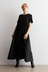 Vestido largo negro oversized con cuello redondo, mangas cortas y detalle fruncido en la cintura con cordón ajustable.