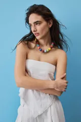 Blusa strapless azul marino de corte asimétrico con terminación en punta y flecos sutiles en el borde inferior, diseño de escote palabra de honor.