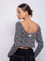 Top de tejido de punto con estampado geométrico en blanco y negro, de manga larga y cuello redondo.